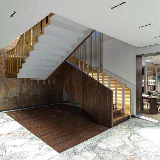 Extravagante Designtreppe mit goldfarbenen Geländer von Saage Treppenbau