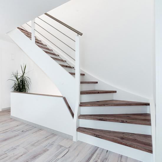 Moderne eingestemmte Treppe mit Vinyl-Treppenstufen von WIEHL Treppen