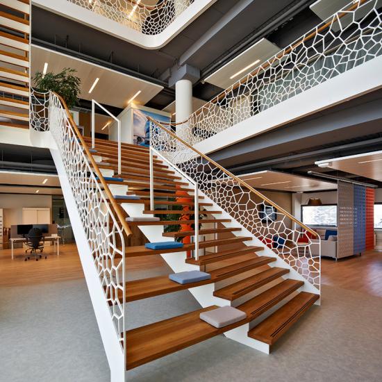 Treppenaufgang am Amsterdamer Flughafen mit Designgeländer mit Sitzgelegenheit von EeStairs DE