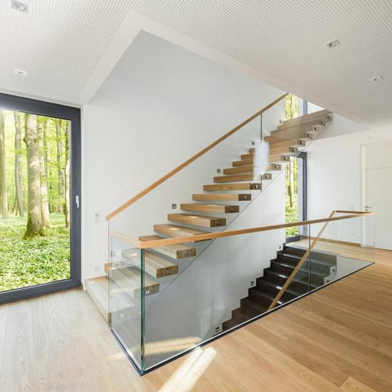 Moderne Kragarmtreppe mit Glasgeländer und Holzhandlauf von BÄTHE TREPPEN