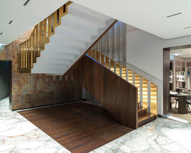 Extravagante Designtreppe mit goldfarbenen Geländer
