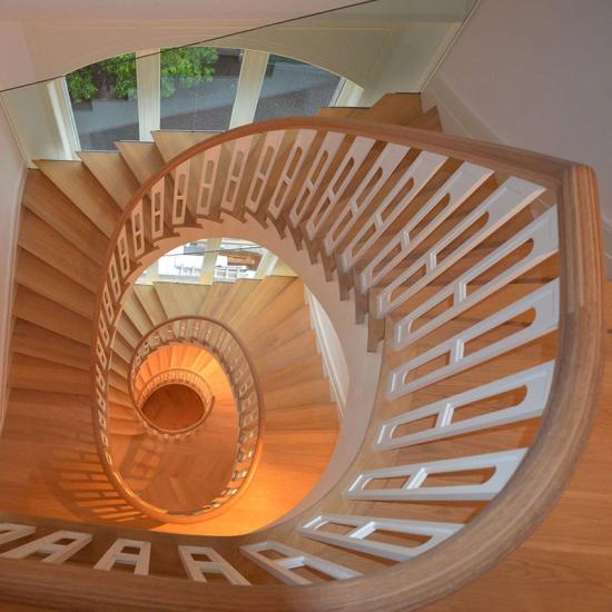 Aufgesattelte Holztreppe mit ovalem Treppenauge von Treppenbau Diehl