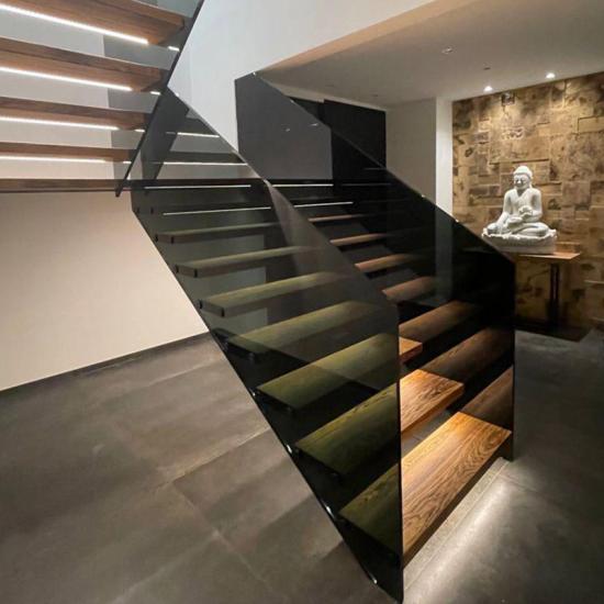 Podesttreppe mit dunklem Glasgeländer und LED Beleuchtung von BECKMANN Treppenmanufaktur