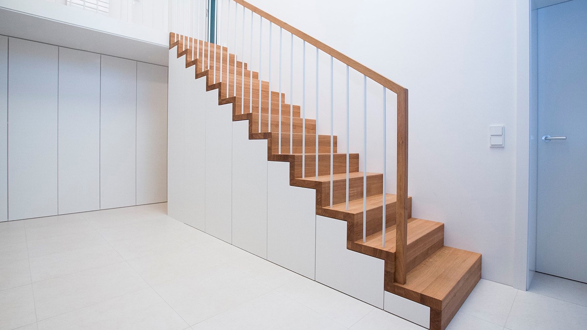 Moderne Stauraumtreppe mit Holzgeländer von WORTMANN Treppen