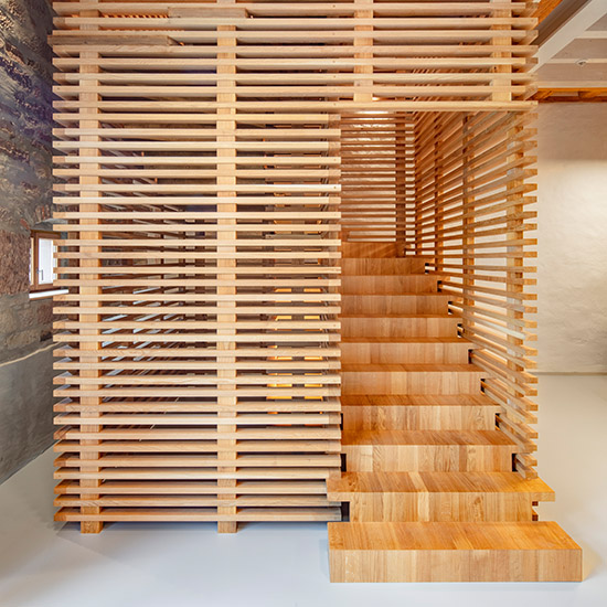 Skulpturale Holztreppe in einem denkmalgeschützten Gebäude von KLEISER Holzbau-Treppenbau